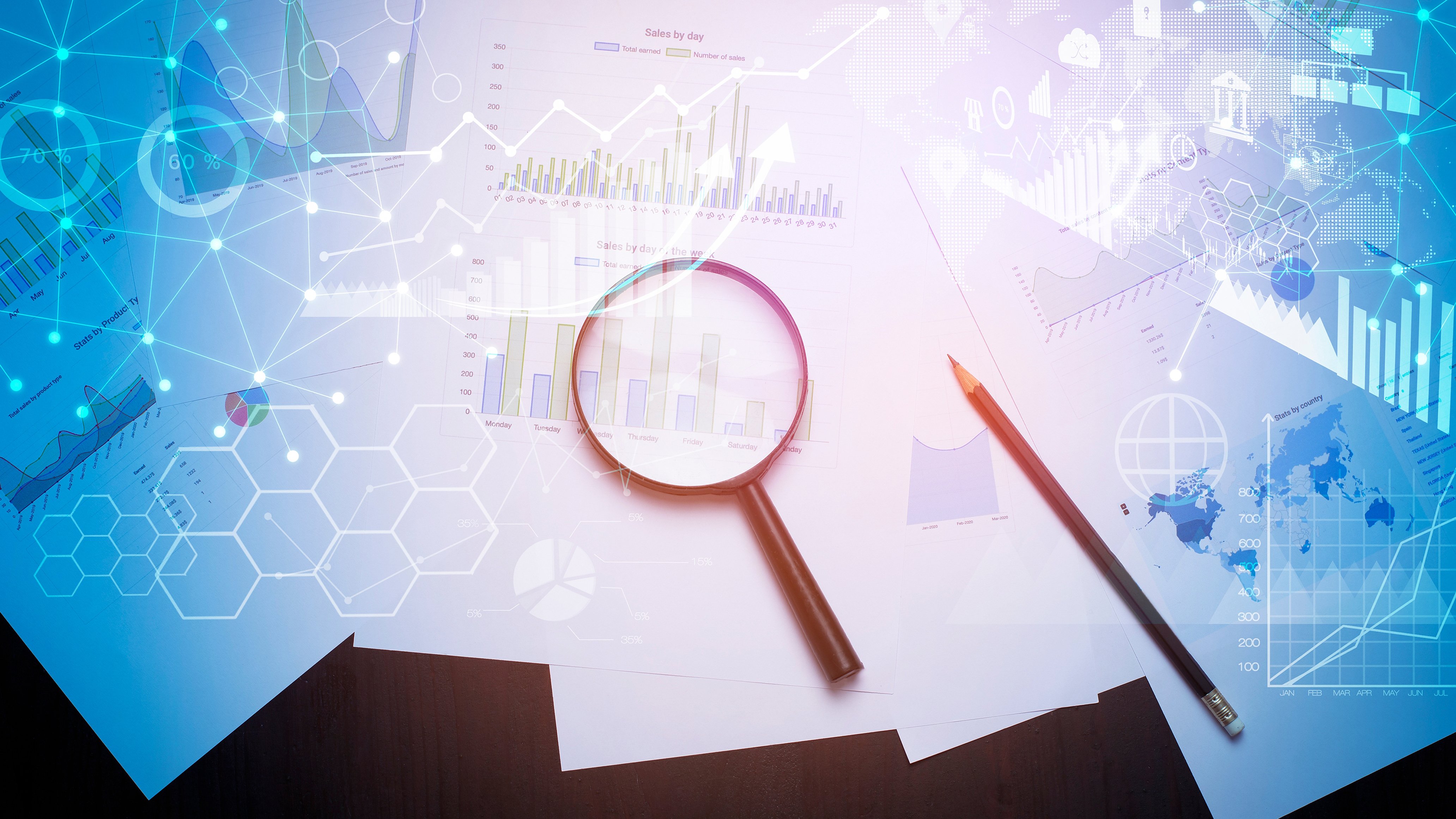Magnifying glass and pencil on reports with charts and graphs overlaid with digital data visuals